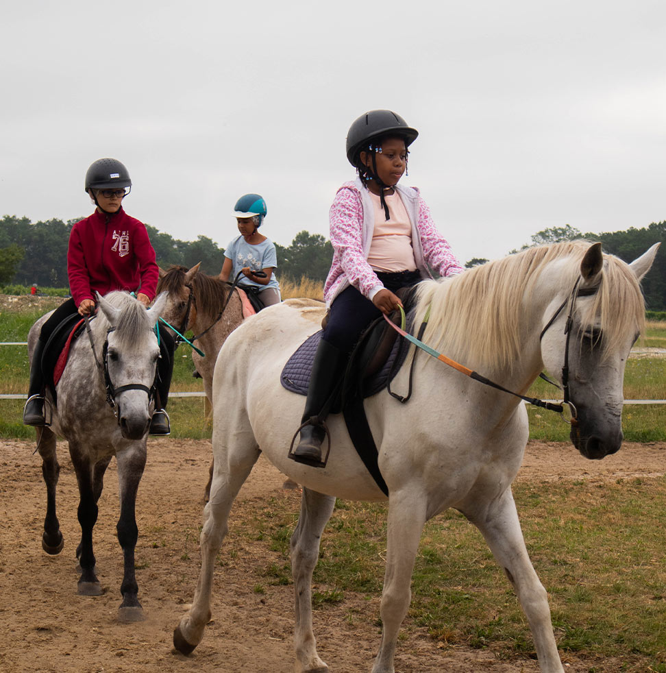 Cours d'équitation avec plusieurs enfants sur des poneys