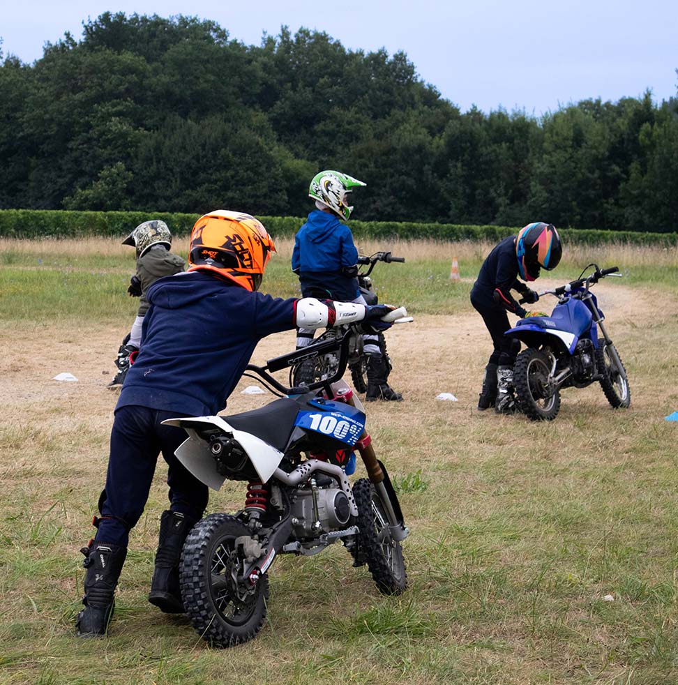 Un enfant qui pousse une moto sur un terrain de moto-cross